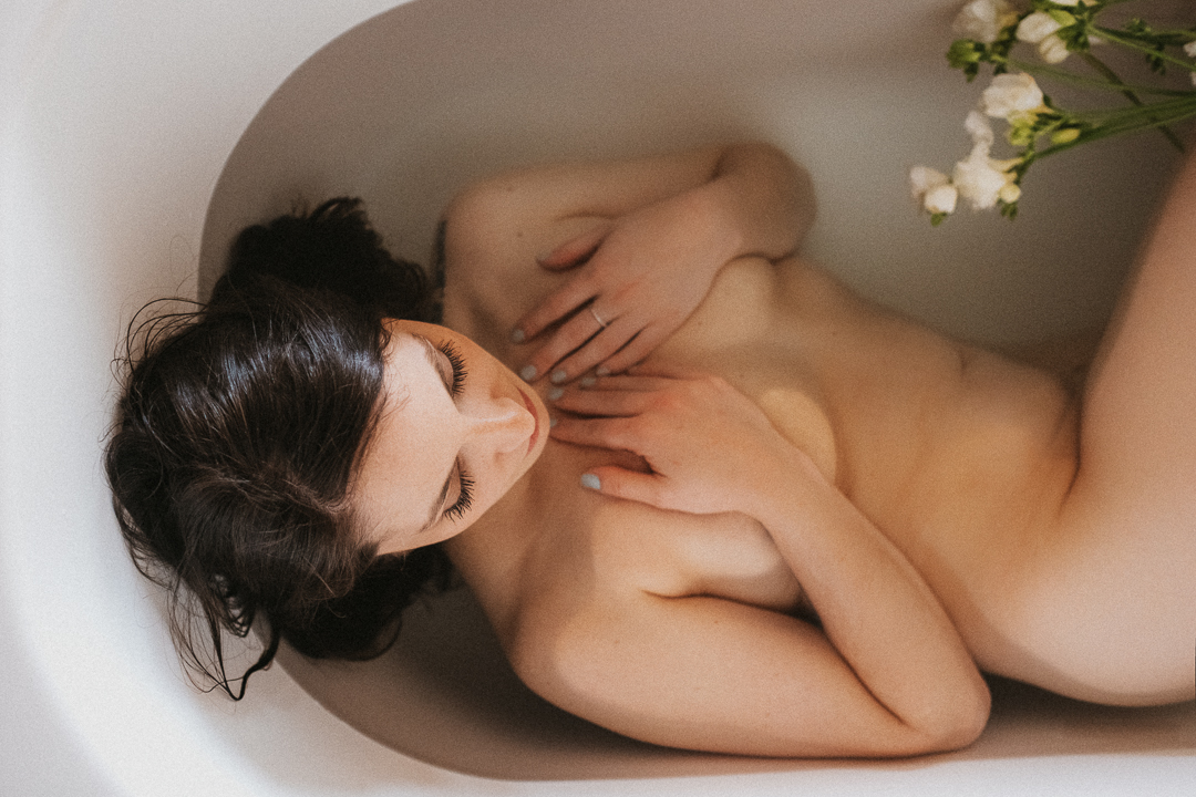 boudoir photography of a woman in a bathtub and flowers