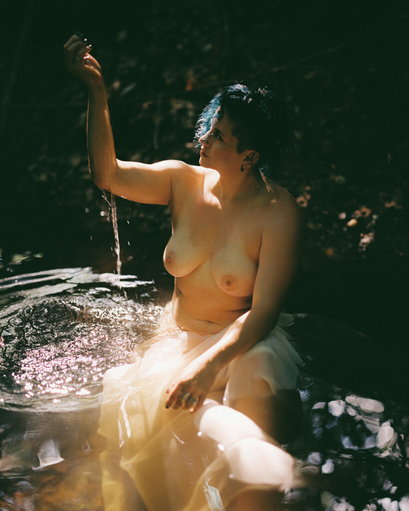 Woman playing in creek with light catching her blue hair in raleigh, nc
