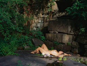 Nude woman laying in front of a rock wall at sunrise, outdoor fine art film photography by K Hammock Photography North Carolina