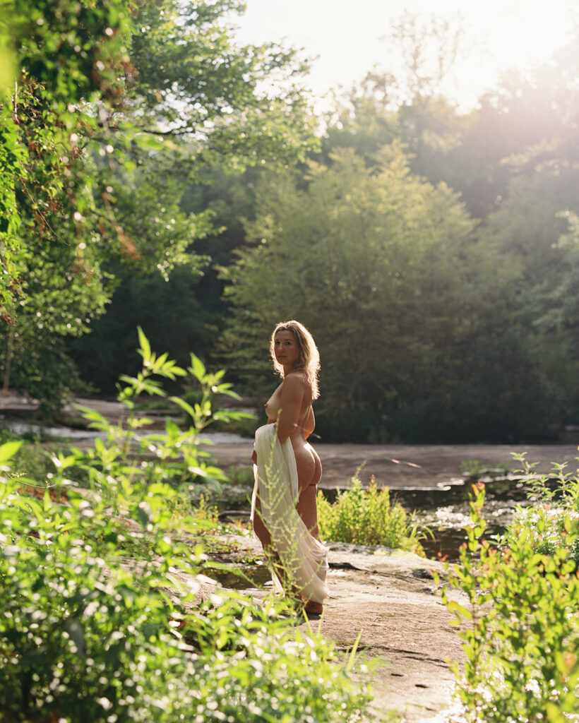 Woman with flowing draped fabric standing at river's edge, fine art boudoir photography by Kristen Hammock North Carolina