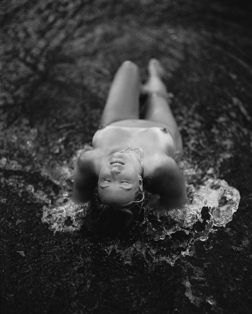 Black and white photo of woman in river with her head arched back, fine art film boudoir photography by Kristen Hammock Durham NC