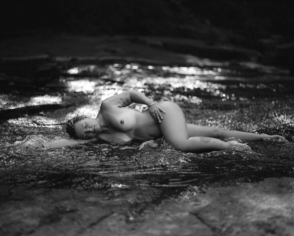 Nude black and white photo of a woman wrapped in river water, outdoor fine art film photography by K Hammock Photography North Carolina