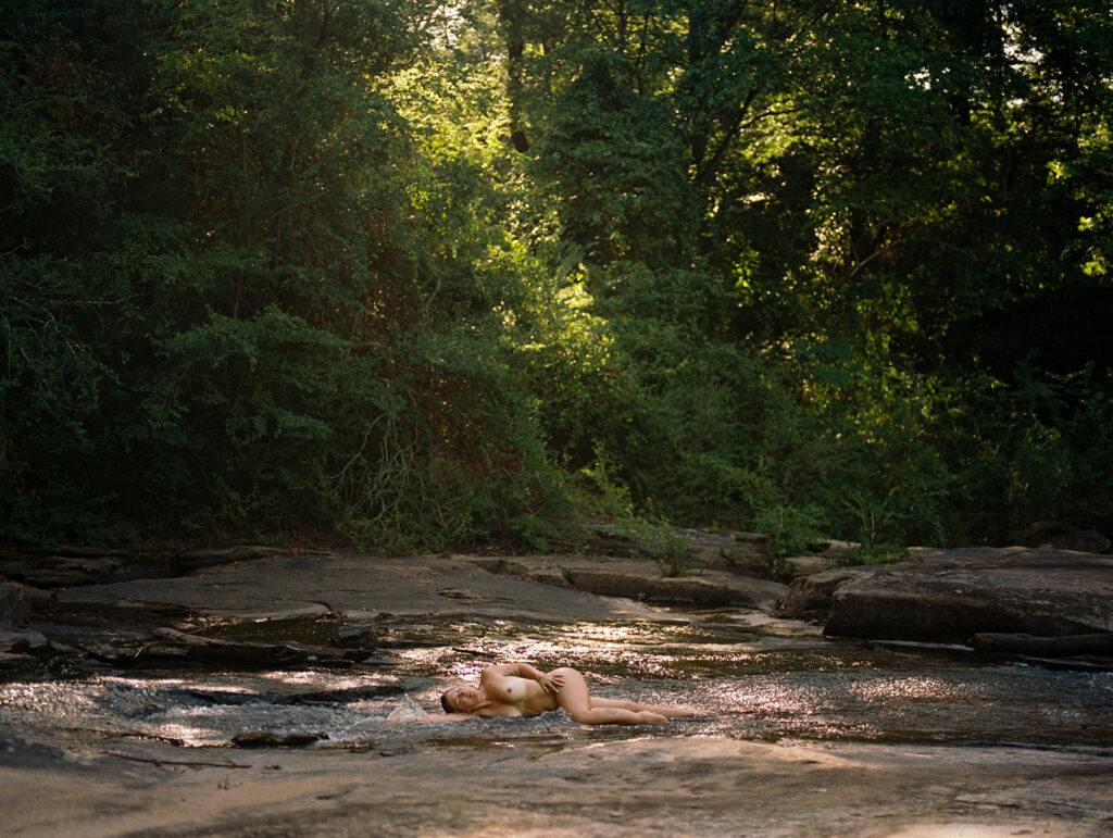 Woman laying nude in clear creek, outdoor fine art film photography by K Hammock Photography North Carolina
